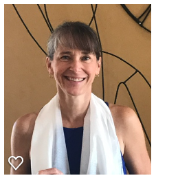 Jen McDonald, a white woman with brown hair and a white neck scarf, smiling at her yoga teacher training graduation