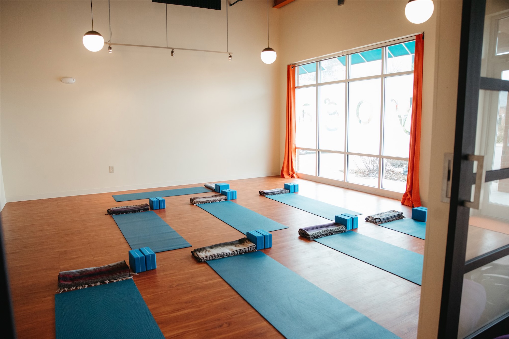 Front room at yoga studio with natural light shining through windows