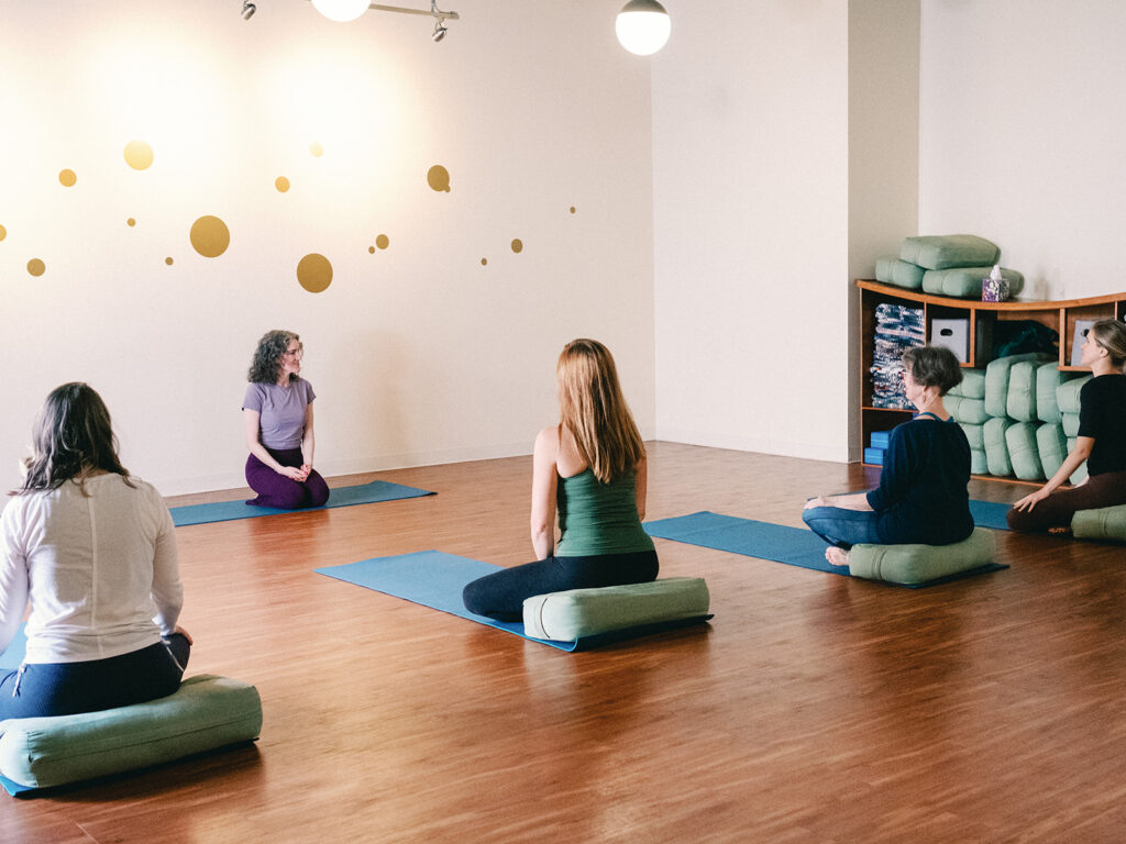 Sage Rountree talks to students at the start of class at Carrboro Yoga, the studio she owns