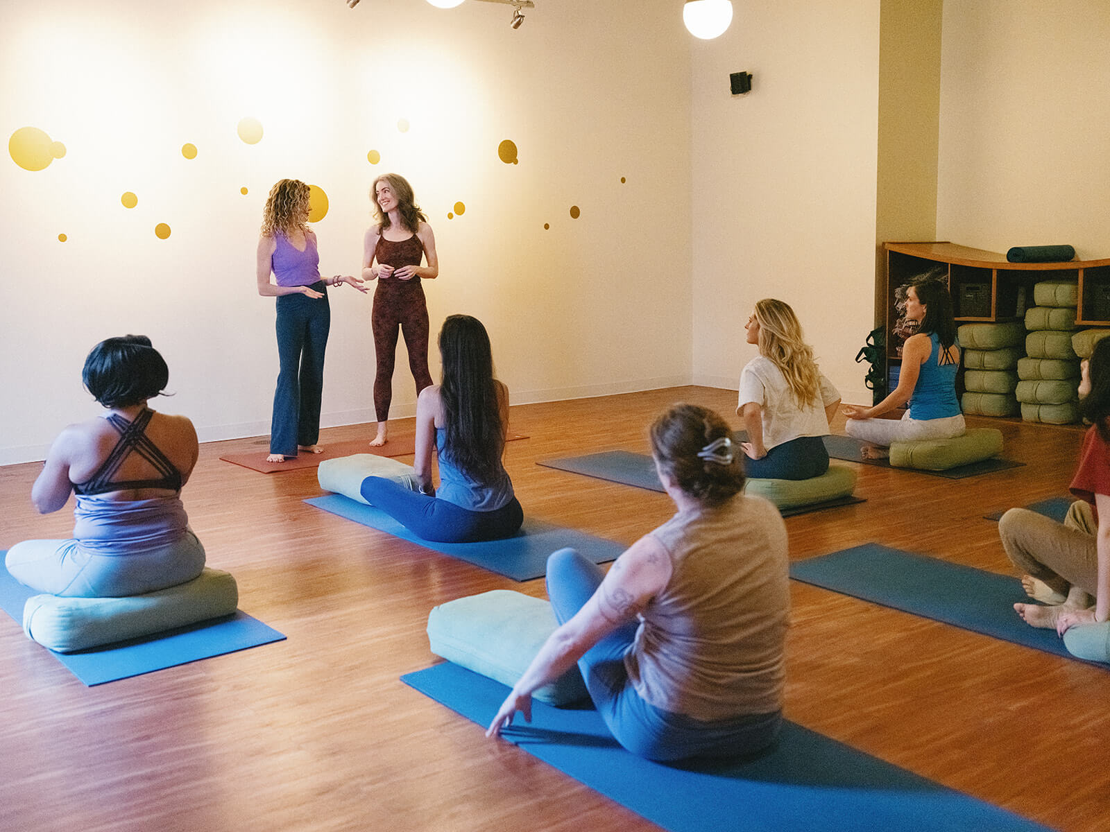 Carrboro Yoga Company teachers stand chatting before class