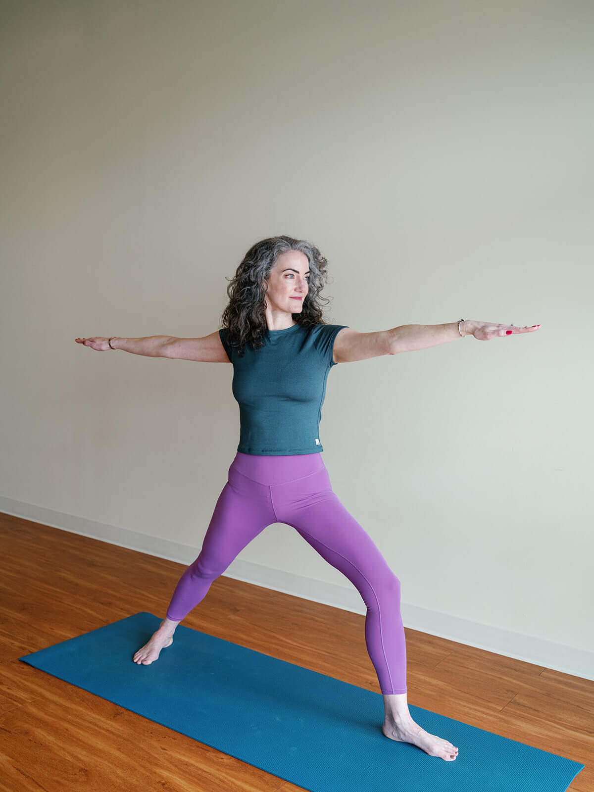 Carrboro Yoga Company a woman standing on a mat with her arms out