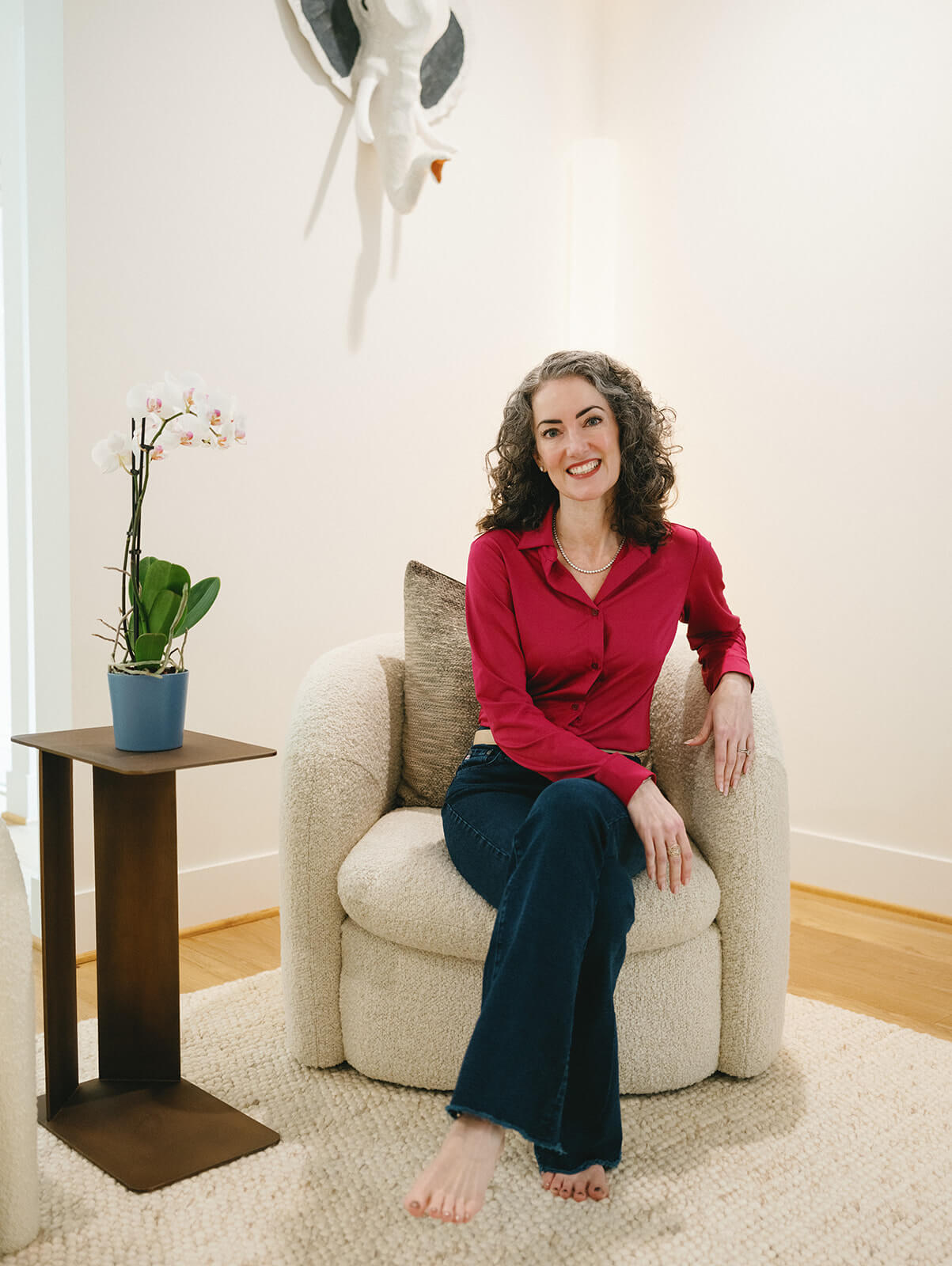 Sage Rountree | Lifestyle Sage Rountree, yoga teacher trainer, sits in a chair, smiling